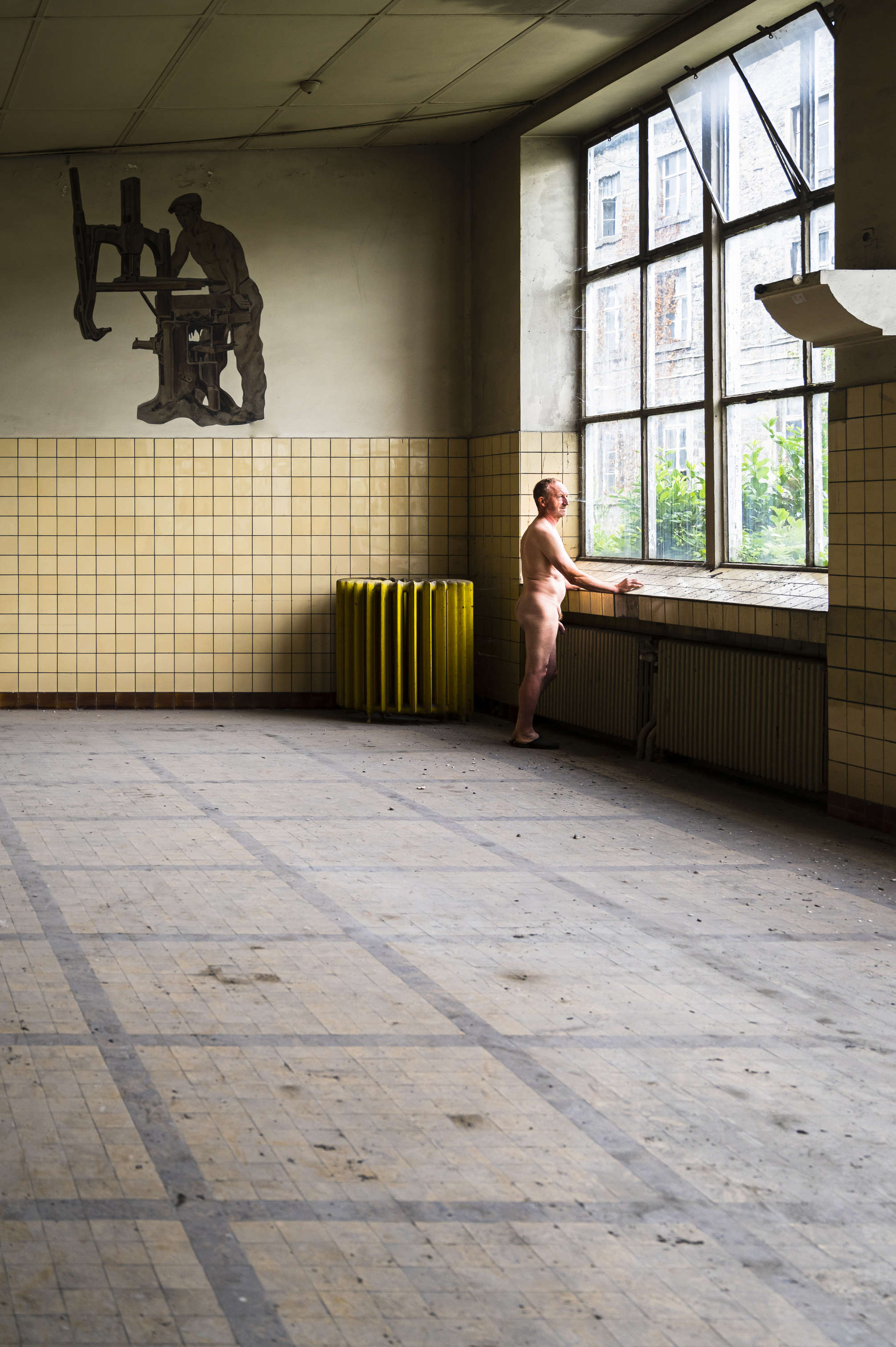 homme posant nu dans un ancien site métallurgique