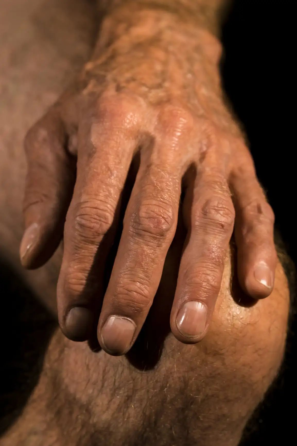La main d'un homme âgé porte les marques de l'âge, texture de la peau étant visible.