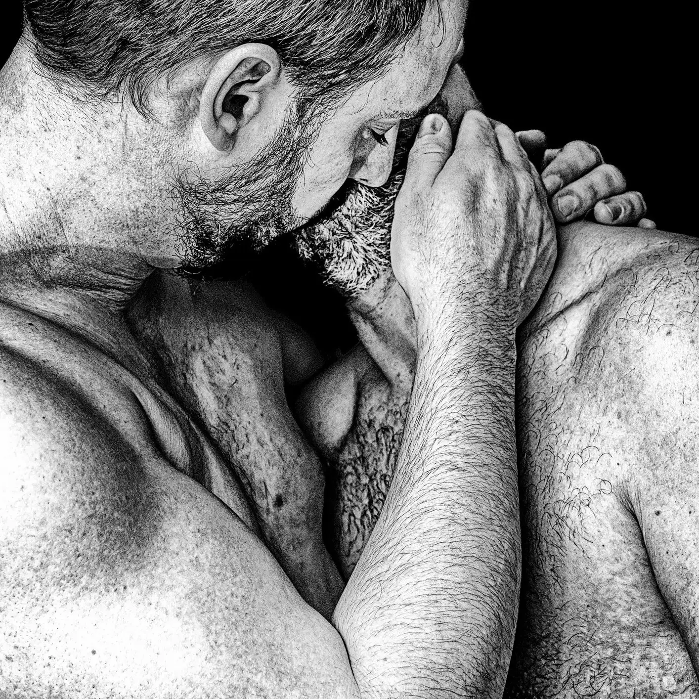 Deux hommes s'enlaçant étroitement, exprimant une profonde affection et une connexion émotionnelle en monochrome