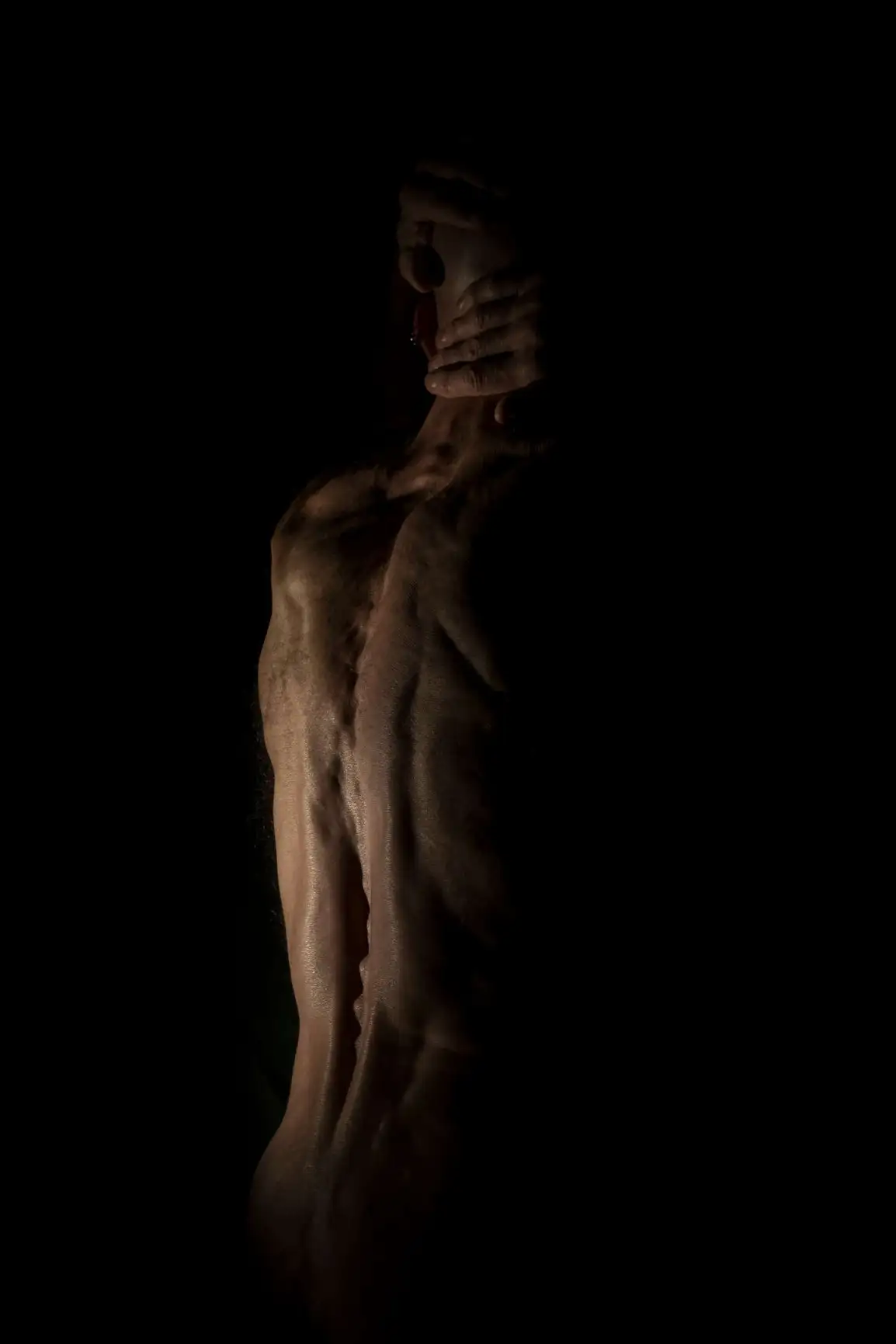 Dos masculin hyper sec et musclé avec ses os apparent et ses mains sur son cou sur fond noir